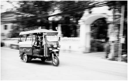 A trishaw scurries through Vientiane, Laos